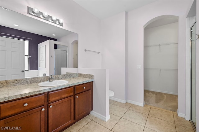 1322 SW 22nd Ave, Cape Coral, FL 33991 - bathroom featuring tile patterned floors, toilet, vanity, a walk in closet, and a stall shower