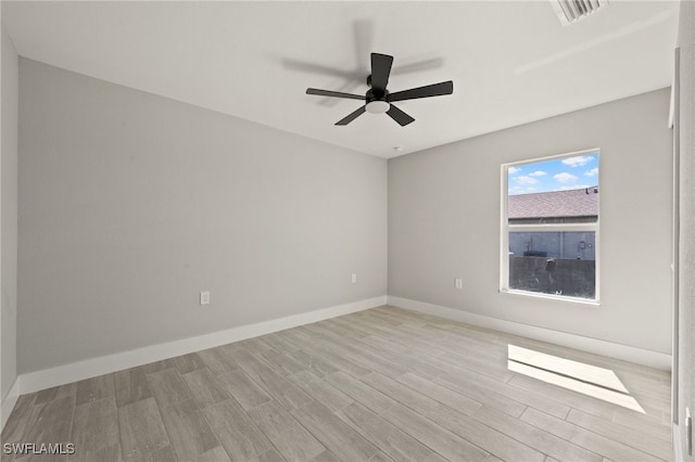 unfurnished room with wood finished floors, visible vents, ceiling fan, and baseboards