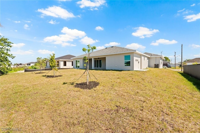 rear view of house with a yard and stucco siding