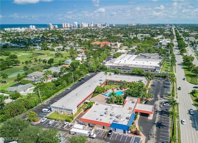 bird's eye view with view of golf course, a view of city, and a water view