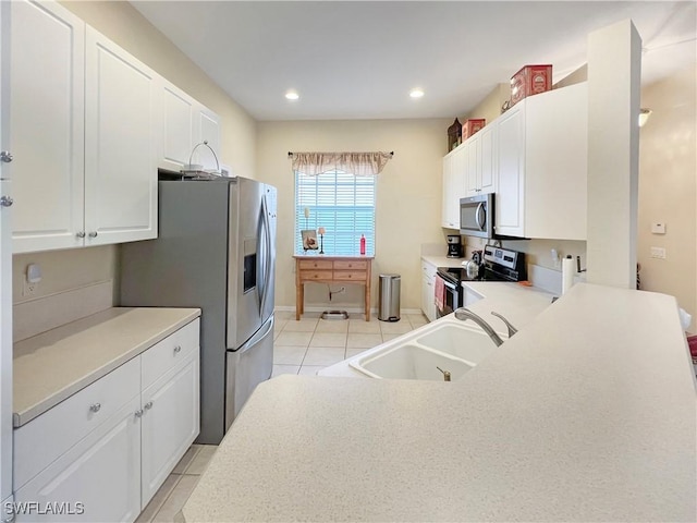 8799 Spring Mountain Way, Fort Myers, FL 33908 - kitchen with appliances with stainless steel finishes, a sink, light countertops, white cabinetry, and light tile patterned floors