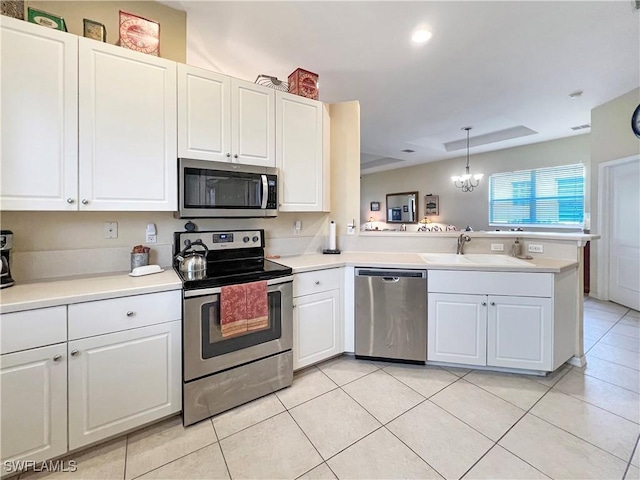 8799 Spring Mountain Way, Fort Myers, FL 33908 - kitchen with appliances with stainless steel finishes, a sink, light countertops, a peninsula, and light tile patterned floors