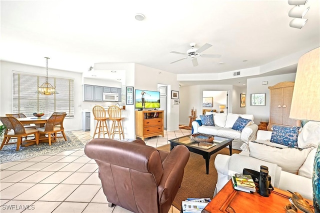 27071 Lake Harbor Ct Unit 103, Bonita Springs, FL 34134 - living room featuring light tile patterned floors, a ceiling fan, and a chandelier