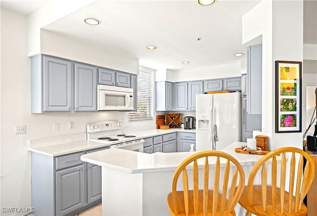 27071 Lake Harbor Ct Unit 103, Bonita Springs, FL 34134 - kitchen featuring white appliances, gray cabinetry, light countertops, and recessed lighting