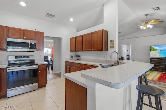 2626 SW 22nd Ave, Cape Coral, FL 33914 - kitchen with a sink, visible vents, a kitchen bar, light countertops, and appliances with stainless steel finishes