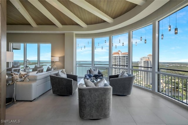 living room with beamed ceiling, wooden ceiling, healthy amount of natural light, tile patterned flooring, and a water view