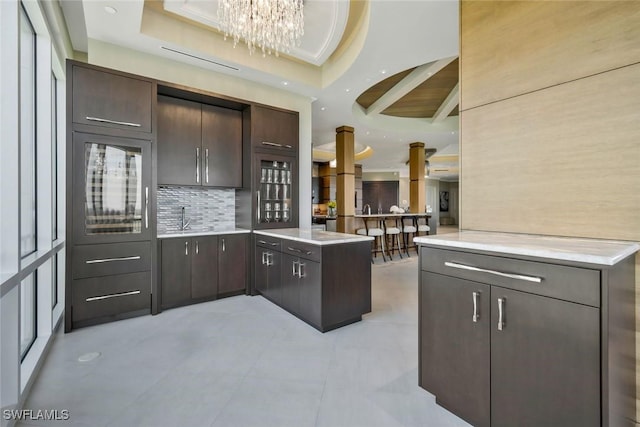 kitchen featuring light countertops, a peninsula, dark brown cabinetry, decorative backsplash, and recessed lighting