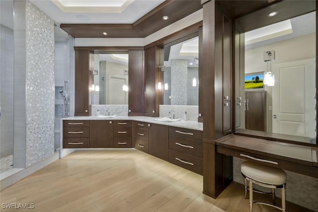 full bathroom with wood finished floors, double vanity, and a walk in shower