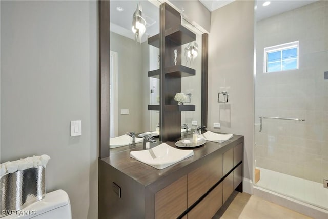 bathroom featuring a shower stall, toilet, double vanity, and recessed lighting