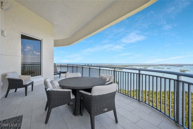 balcony featuring a water view and outdoor dining space