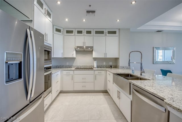 kitchen with a sink, light tile patterned floors, appliances with stainless steel finishes, white cabinetry, and under cabinet range hood