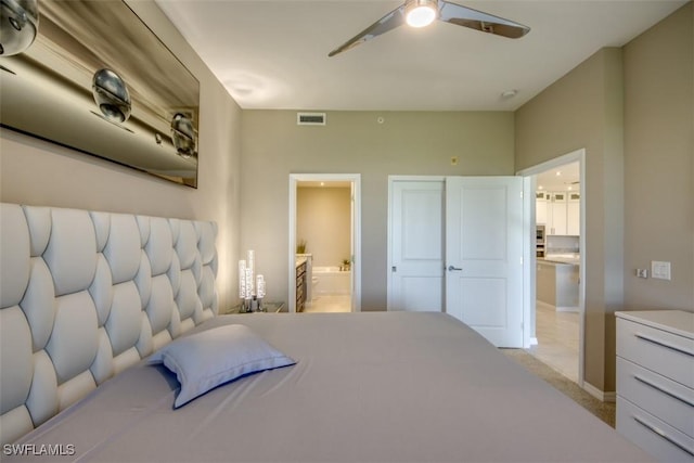 bedroom with visible vents, baseboards, light colored carpet, ceiling fan, and ensuite bathroom
