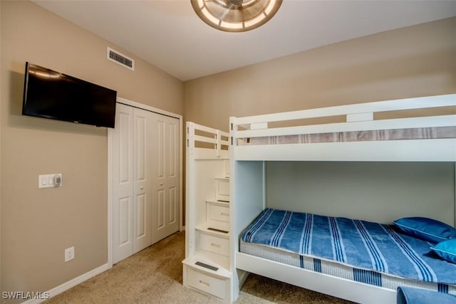 unfurnished bedroom with a closet, carpet, visible vents, and baseboards