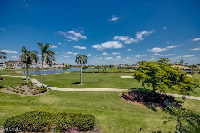 view of home's community featuring golf course view, a yard, and a water view