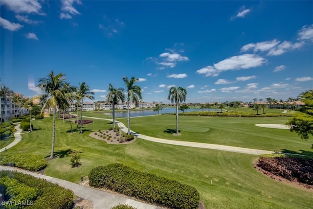 view of home's community featuring golf course view, a lawn, and a water view