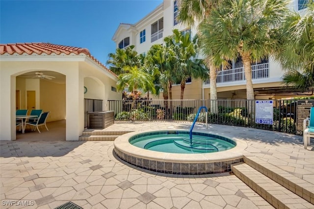 view of swimming pool featuring fence, a community hot tub, a patio area, and ceiling fan