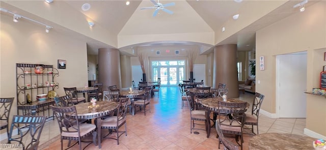 dining room featuring light tile patterned flooring, ceiling fan, arched walkways, baseboards, and vaulted ceiling