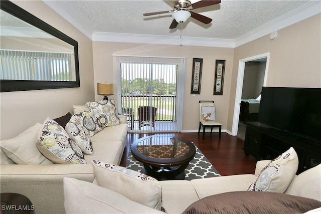 living room with ceiling fan, a textured ceiling, baseboards, wood finished floors, and ornamental molding