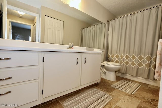 full bathroom featuring a shower with shower curtain, toilet, stone finish floor, and vanity