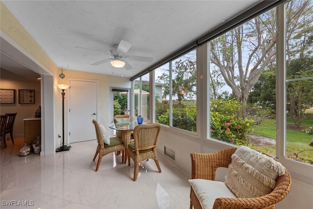 sunroom / solarium featuring a ceiling fan
