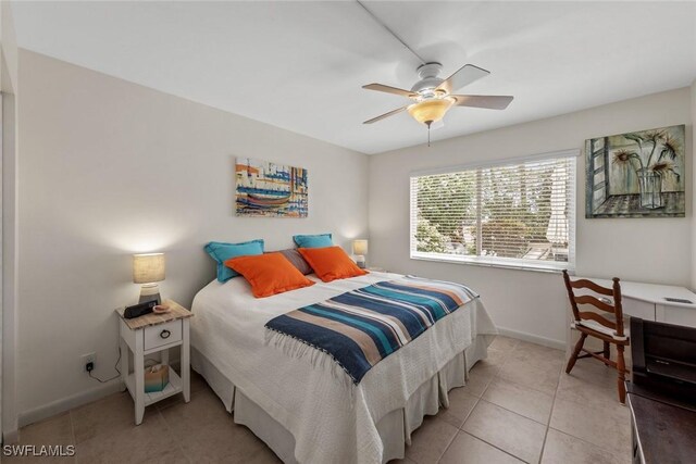 tiled bedroom with baseboards and a ceiling fan