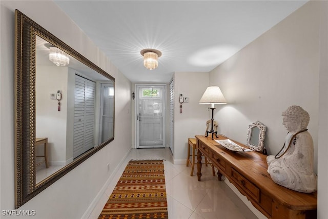 foyer entrance featuring baseboards and light tile patterned flooring
