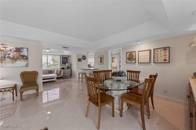 dining area featuring a tray ceiling, visible vents, marble finish floor, and baseboards
