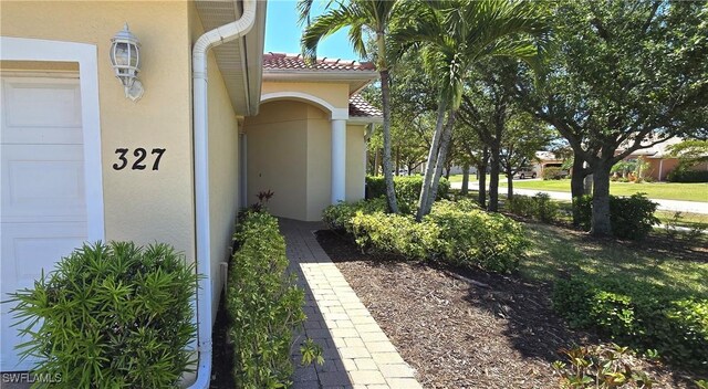327 Monaco Dr Unit 12, Punta Gorda, FL 33950 - doorway to property featuring stucco siding and a tile roof