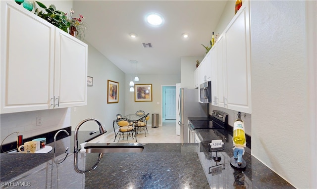 327 Monaco Dr Unit 12, Punta Gorda, FL 33950 - kitchen featuring dark stone countertops, a sink, white cabinets, stainless steel appliances, and backsplash