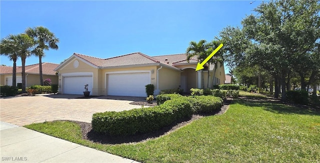327 Monaco Dr Unit 12, Punta Gorda, FL 33950 - ranch-style home with a tiled roof, stucco siding, an attached garage, decorative driveway, and a front yard