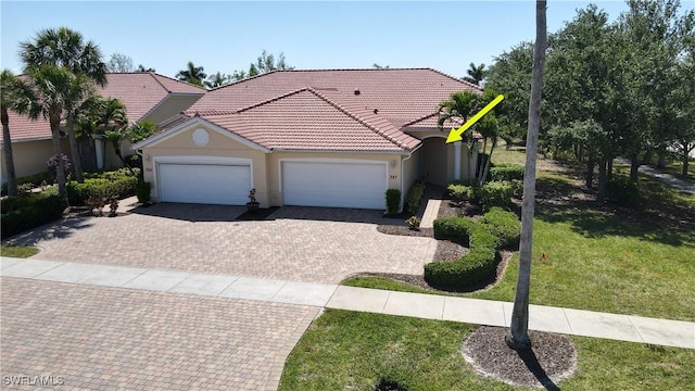 327 Monaco Dr Unit 12, Punta Gorda, FL 33950 - view of front of home with a tiled roof, a front lawn, stucco siding, an attached garage, and decorative driveway