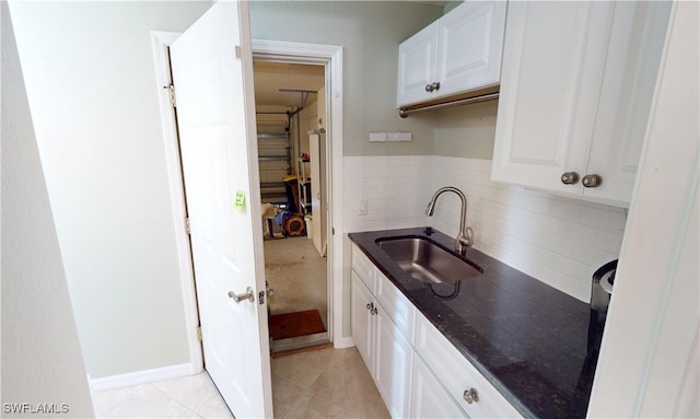 327 Monaco Dr Unit 12, Punta Gorda, FL 33950 - kitchen featuring dark stone counters, a sink, decorative backsplash, light tile patterned flooring, and white cabinetry