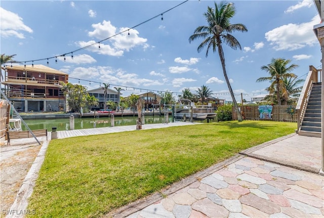 view of yard featuring a water view, stairway, and fence