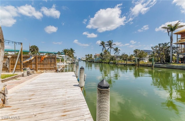 dock area with a water view and fence