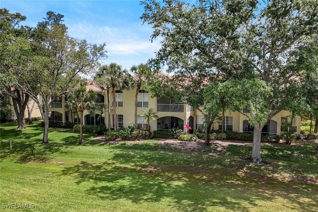 93 Silver Oaks Cir Unit 3-101, Naples, FL 34119 - view of front of home featuring stucco siding and a front yard