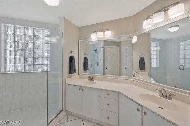 93 Silver Oaks Cir Unit 3-101, Naples, FL 34119 - full bathroom with double vanity, a sink, a shower stall, and tile patterned floors