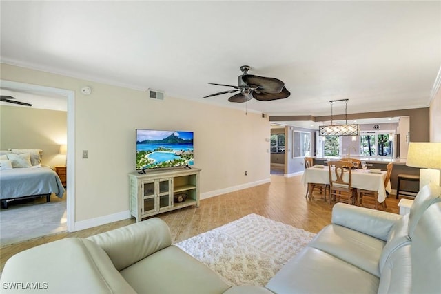 3051 Sandpiper Bay Cir Unit I102, Naples, FL 34112 - living room with a ceiling fan, crown molding, baseboards, and light wood-style flooring