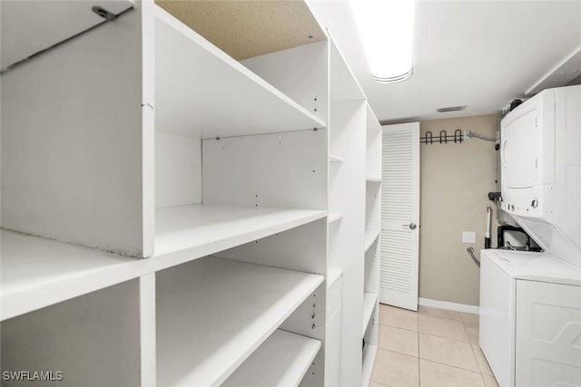 3051 Sandpiper Bay Cir Unit I102, Naples, FL 34112 - laundry area with estacked washer and dryer and light tile patterned floors