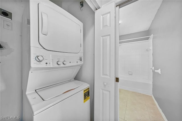2061 Willow Hammock Cir Unit 303, Punta Gorda, FL 33983 - laundry area featuring stacked washer / drying machine, baseboards, light tile patterned floors, and laundry area