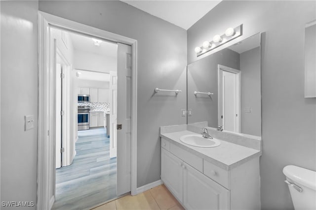 2061 Willow Hammock Cir Unit 303, Punta Gorda, FL 33983 - half bath featuring vanity, tile patterned flooring, tasteful backsplash, and toilet