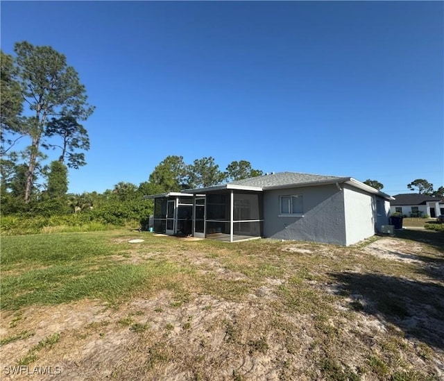 5031 Locke Ln, Lehigh Acres, FL 33973 - rear view of property with a sunroom and stucco siding