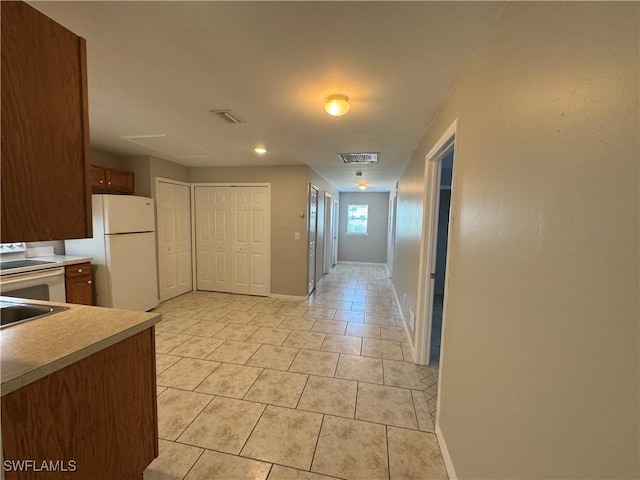 5031 Locke Ln, Lehigh Acres, FL 33973 - kitchen featuring light tile patterned flooring, freestanding refrigerator, visible vents, and light countertops