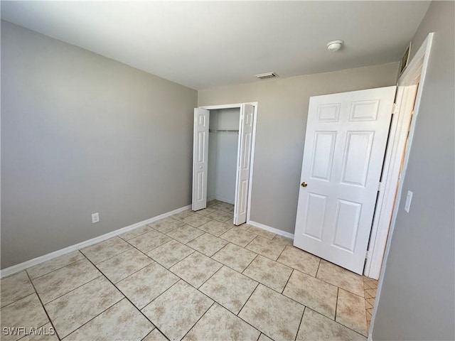 5031 Locke Ln, Lehigh Acres, FL 33973 - unfurnished bedroom with baseboards, visible vents, a closet, and light tile patterned floors