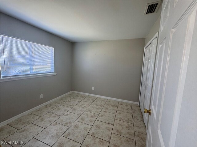 5031 Locke Ln, Lehigh Acres, FL 33973 - unfurnished bedroom featuring baseboards, light tile patterned flooring, and visible vents
