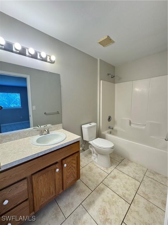 5031 Locke Ln, Lehigh Acres, FL 33973 - bathroom with tile patterned floors, vanity, shower / washtub combination, toilet, and visible vents