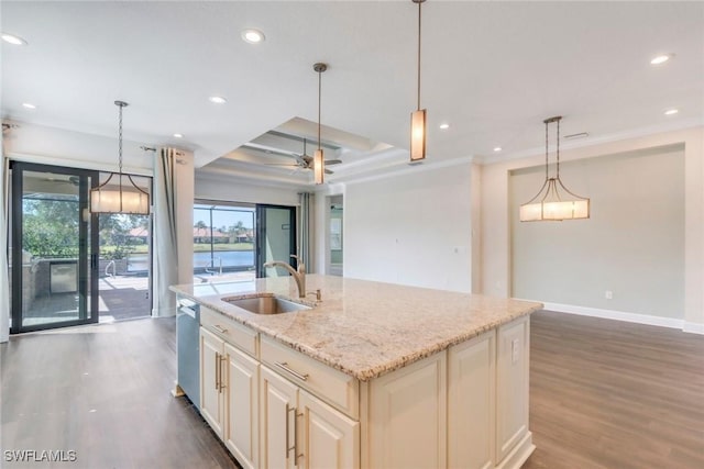 kitchen with recessed lighting, wood finished floors, stainless steel dishwasher, a sink, and crown molding