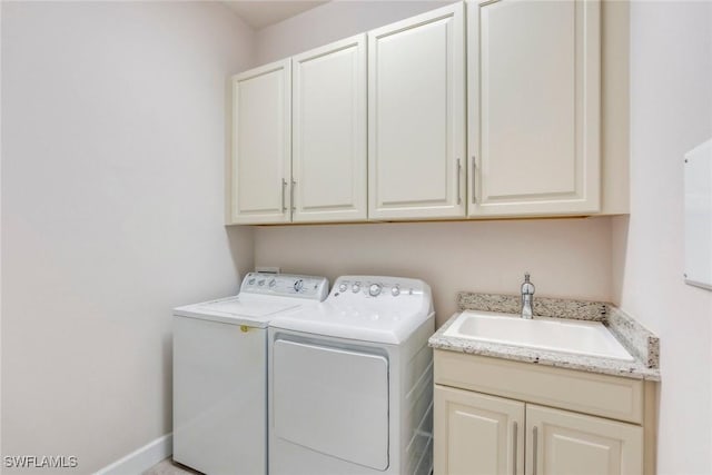 washroom with washing machine and clothes dryer, a sink, and cabinet space