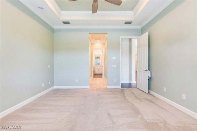 unfurnished bedroom with ornamental molding, carpet flooring, visible vents, and a raised ceiling
