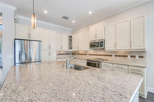 kitchen featuring a sink, visible vents, backsplash, appliances with stainless steel finishes, and ornamental molding