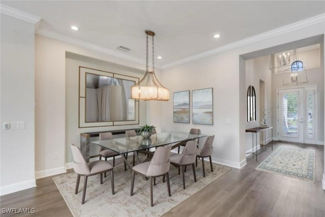 dining area featuring visible vents, baseboards, wood finished floors, and a notable chandelier